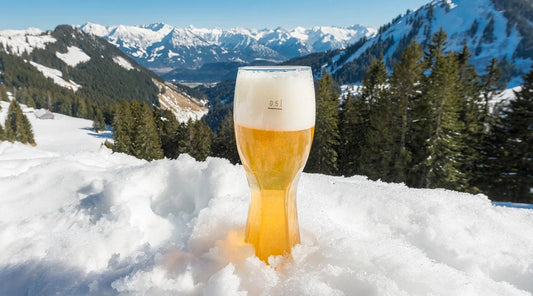 Glas weissbier in de sneeuw op een berg